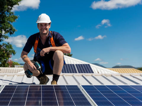 Construction Worker Installing Solar Panels on white roof