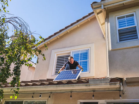 Man Installing Solar Panel on Roof