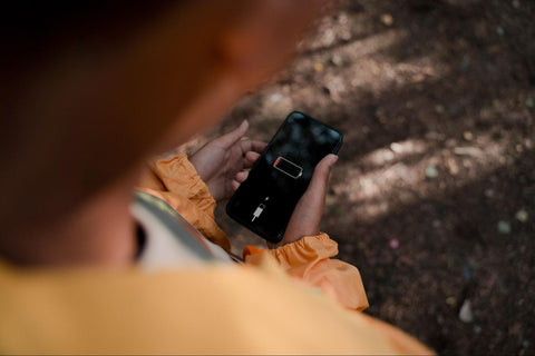 man holding cell phone with no charge screen