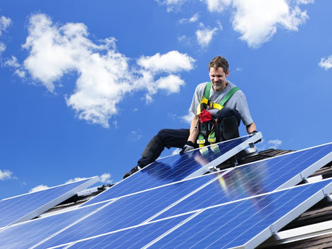 solar panel installer on top of roof installing solar panel