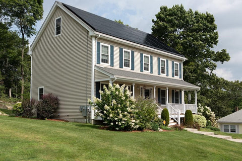 beige two-story house with solar panels covering the roof
